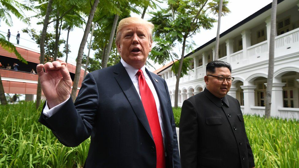 President Donald Trump walks with Kim Jong-un in Singapore