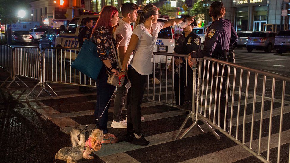 People try to access the area near an explosion in New York