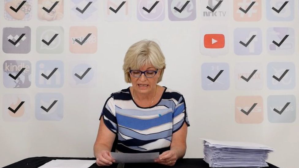 A Norwegian woman reads out terms and conditions from a smartphone app