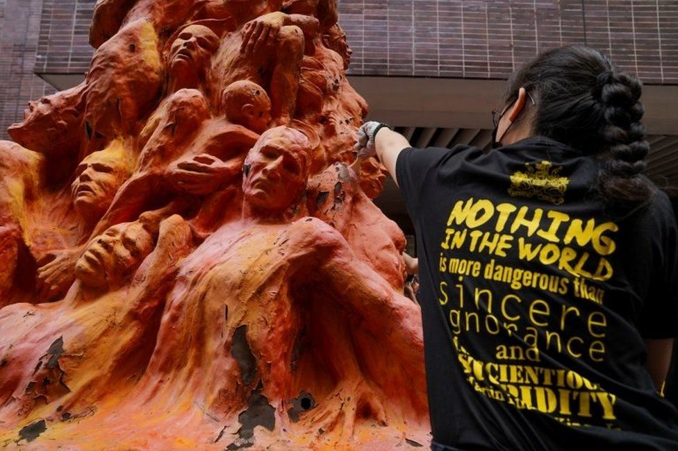 A University student cleans the "Pillar of Shame" statue at the University of Hong Kong on the 32nd anniversary of the crackdown on pro-democracy demonstrators at Beijing"s Tiananmen Square in 1989, in Hong Kong, China June 4, 2021