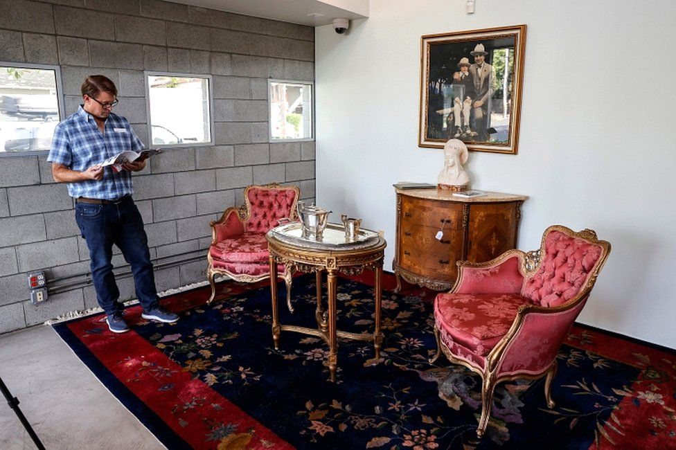 Witherell's Gallery founder Brian Witherell stands next to some of the furniture and artwork that belonged to American gangster Al Capone displayed ahead of an auction in Sacramento, California, on 5 October 2021