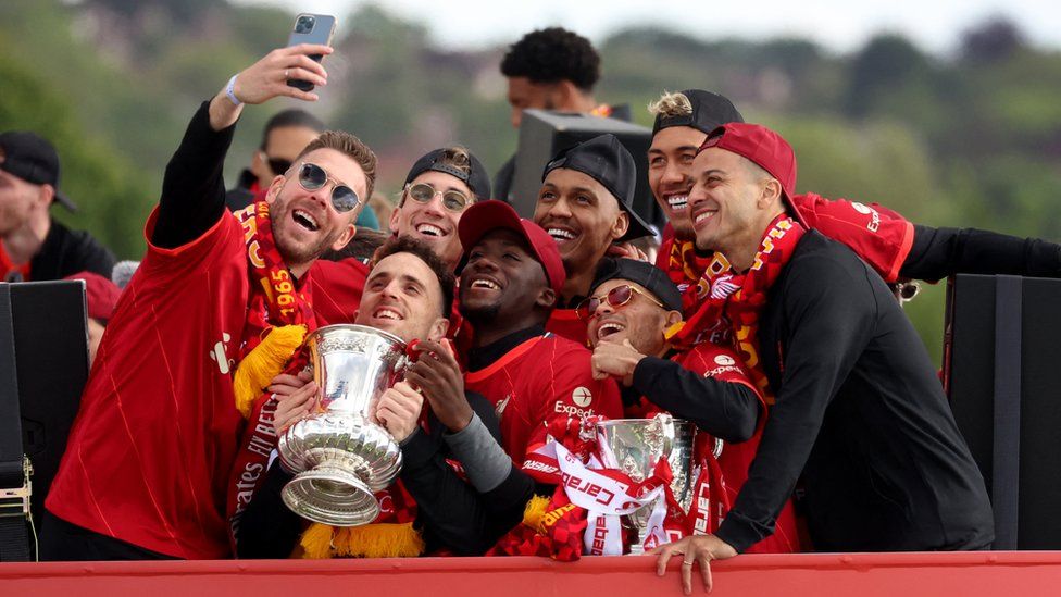 Liverpool's Adrian poses for a selfie alongside Diogo Jota, Ibrahima Konate, Luis Diaz, Thiago Alcantara, Roberto Firmino, Fabinho and Kostas Tsimikas with the FA Cup trophy and the Carabao Cup trophy