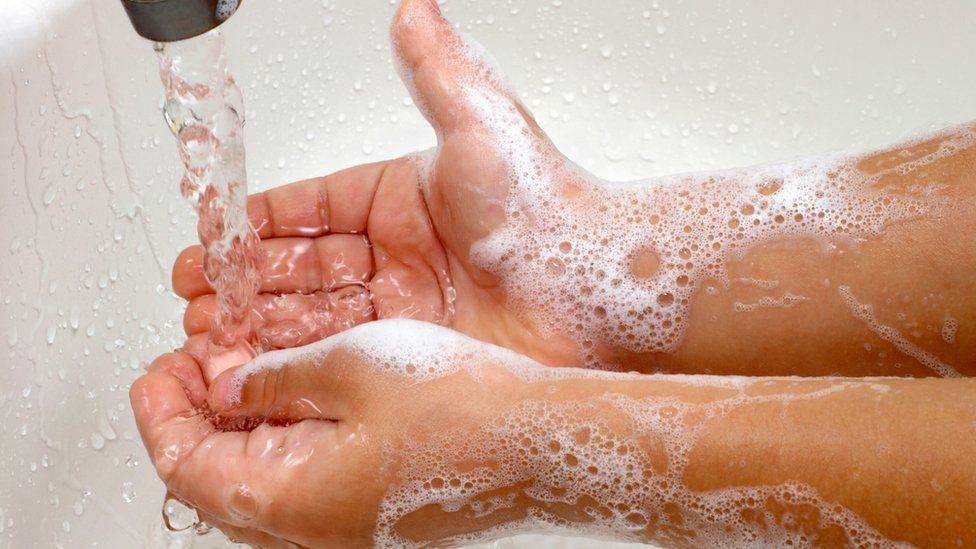 Child washing hands with soap