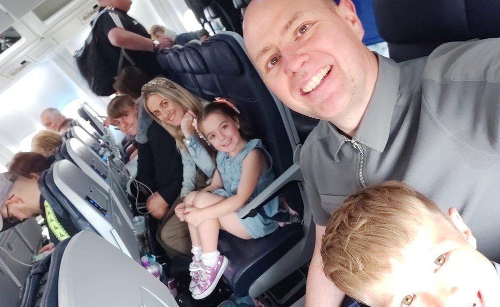 Rob Gore and his family smiling on a flight