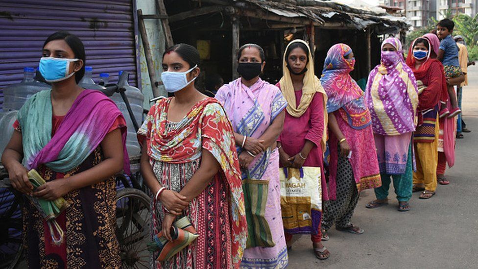 Women stand in a queue to get free ration in Kolkata
