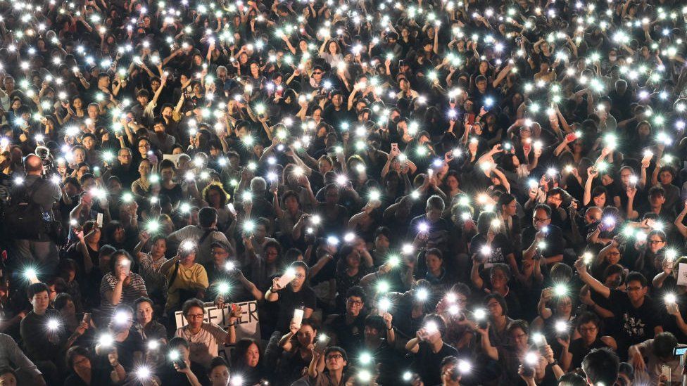 Demonstrators hold up lights from their phones during a rally organised by Hong Kong mothers in support of extradition law protesters, in Hong Kong on July 5, 2019