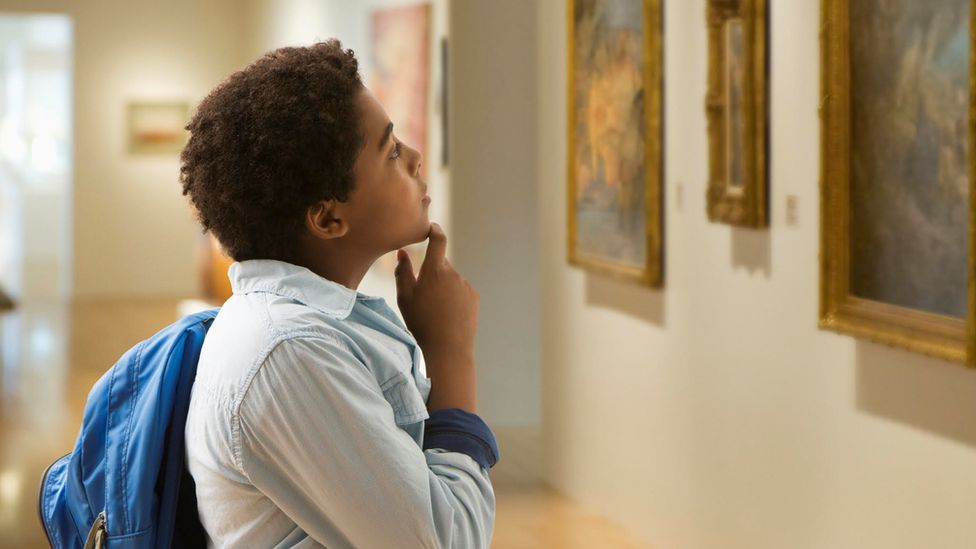 child looks at art in a gallery