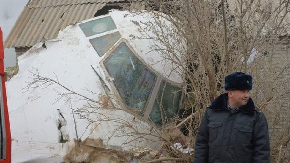 A policeman in front of a Boeing 747 which landed on houses outside Bishkek, Kyrgyzstan (16 Jan 2016)