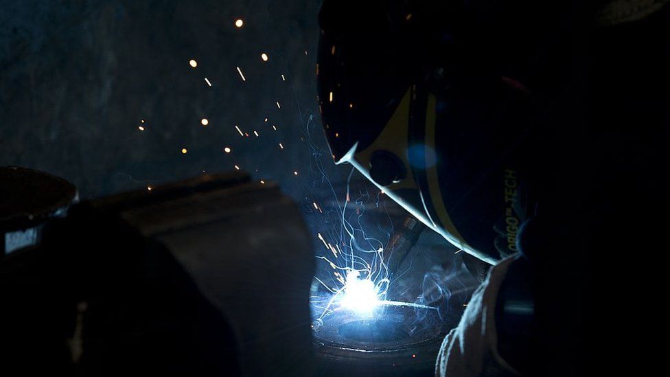 An engineer welding metal