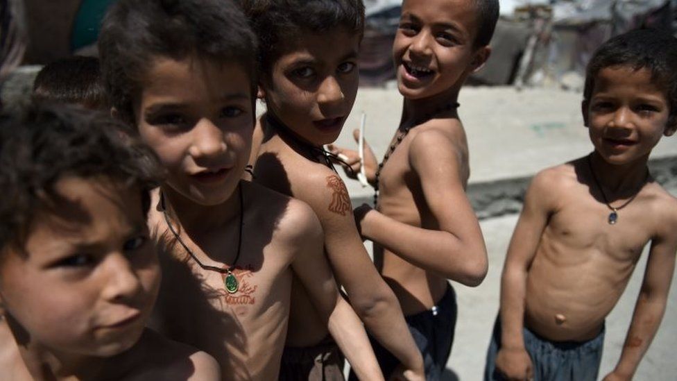 In this photograph taken on June 20, 2016, internally displaced Afghan children pose at a refugee camp in Kabul. Pakistan hosts 1.4 million registered Afghan refugees, according to UNHCR, making it the third-largest refugee hosting nation in the world.
