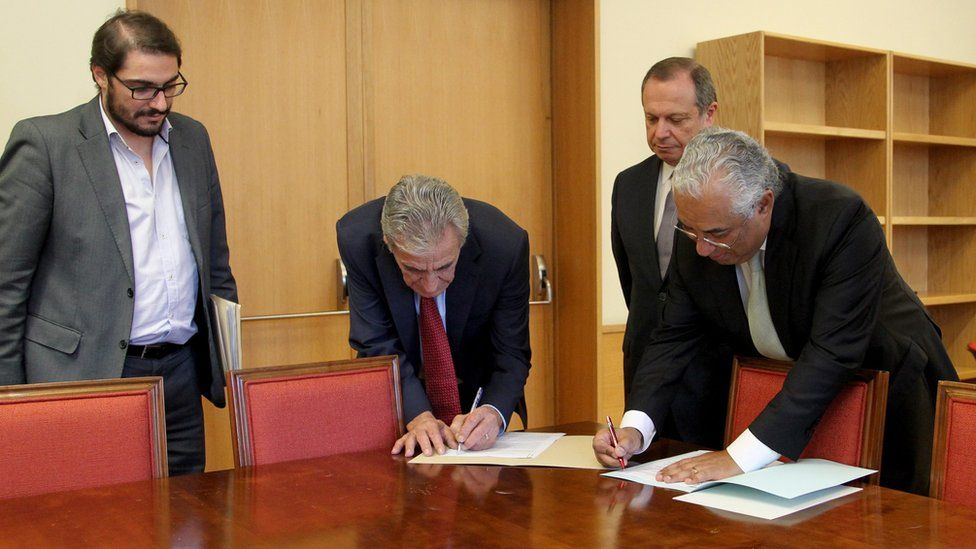 Socialist leader Antonio Costa (R) with Communist leaders signing deal (10 Nov)