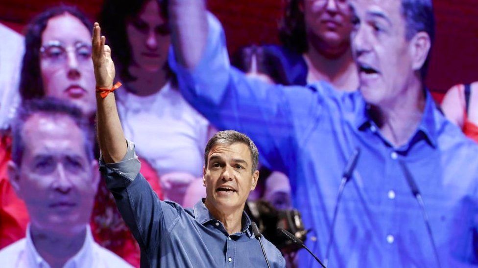 Spain's Prime Minister Pedro Sanchez stands on stage in front of a screen showing his face at a meeting of his party, PSOE, in the city of Valencia, Spain, 15 July 2023.