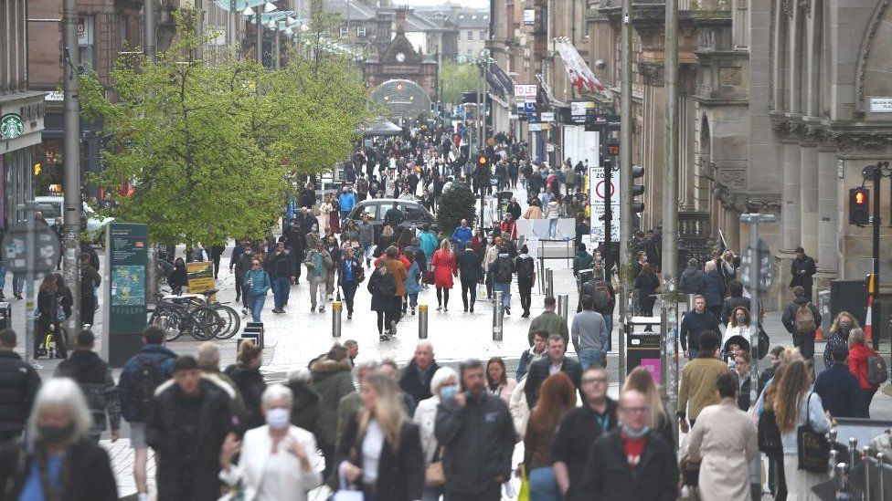 Pedestrians walk in shopping precinct in Glasgow