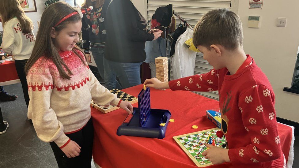 Two children play Connect Four