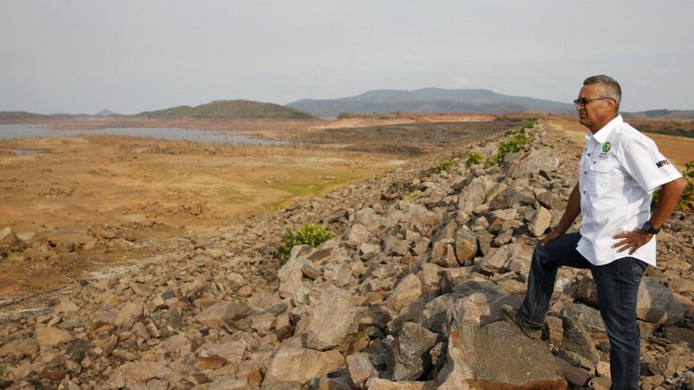 Electricity Minister Luis Motta looks at previously submerged land during an inspection at the Guri Dam in Bolivar state, Venezuela April 11, 2016