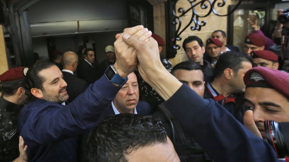 Lebanese prime minister Saad Hariri (L) greets his supporters upon his arrival at his home in Beirut