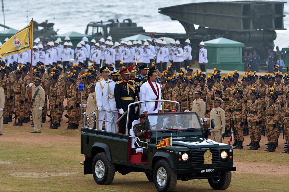 Sri Lankan President Mahinda Rajapakse (C) rides in a jeep during a Victory Day parade in Colombo on May 18, 2013.