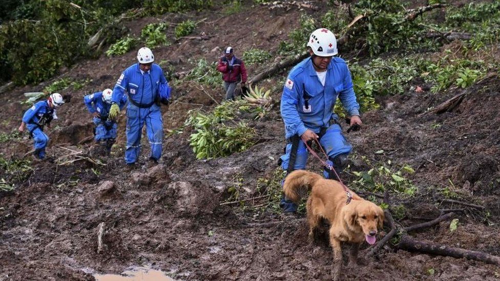 Manuel Bermudez (R), member of the Colombian Red Cross and his dog Gretta, search for victims after a landslide in Rosas, Valle del Cauca department, in south-western Colombia, on April 21, 2019