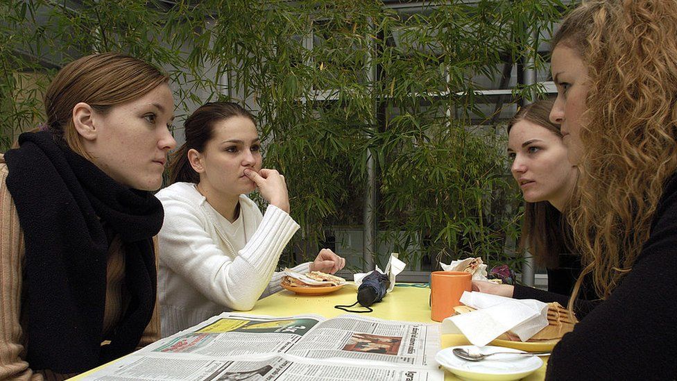 Law school students. A national daily newspaper lies open on a table at the cafeteria.