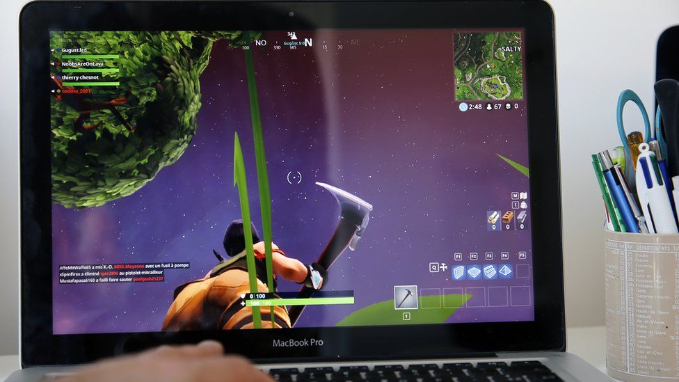 A gamer watches Fortnite on their laptop