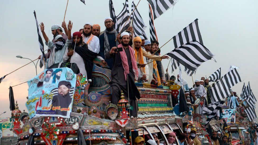 Supporters of the Islamist Jamiat Ulema-e-Islam (JUI-F) wave party flags atop a vehicle as they take part in an anti-government "Azadi (Freedom) March" towards Islamabad, from Peshawar on October 31, 2019