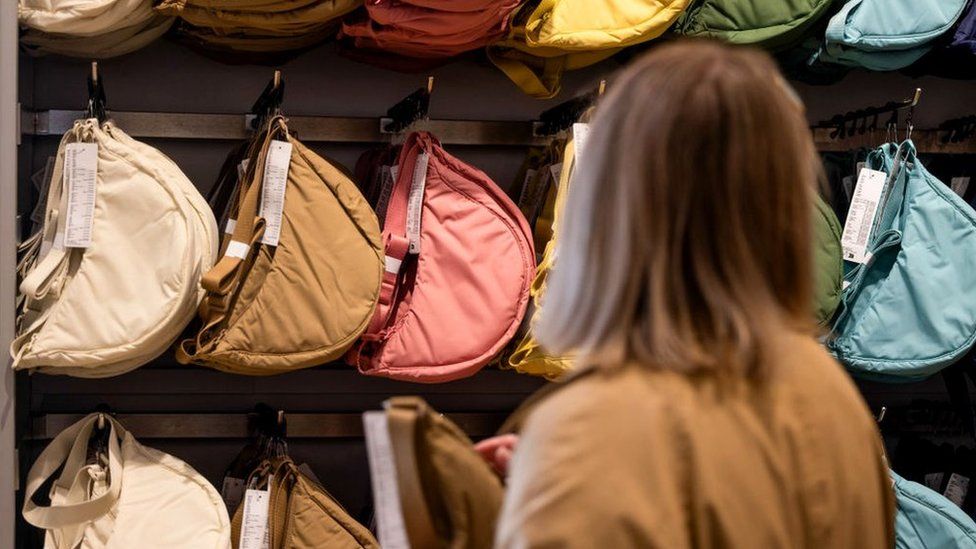 Woman looking at Uniqlo shoulder bags