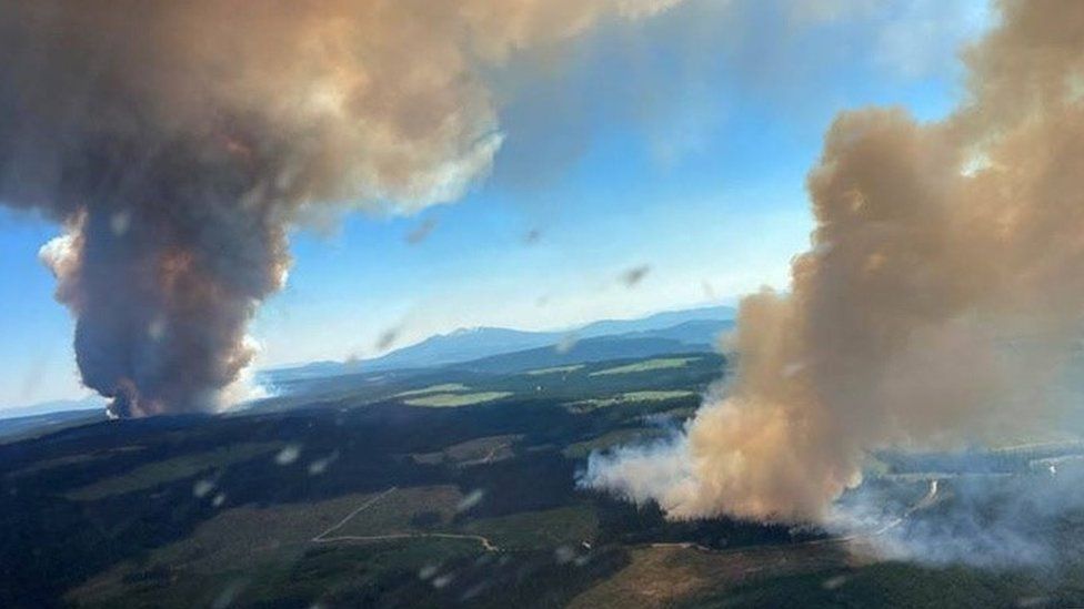 Дым поднимается от лесного пожара на озере Лонг-Лох и Дерриксон в центре Оканагана, Британская Колумбия, Канада, 30 июня 2021 г.