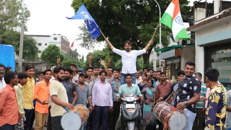 Ambedkar Vichar Manch activist celebrating with drums and flags.