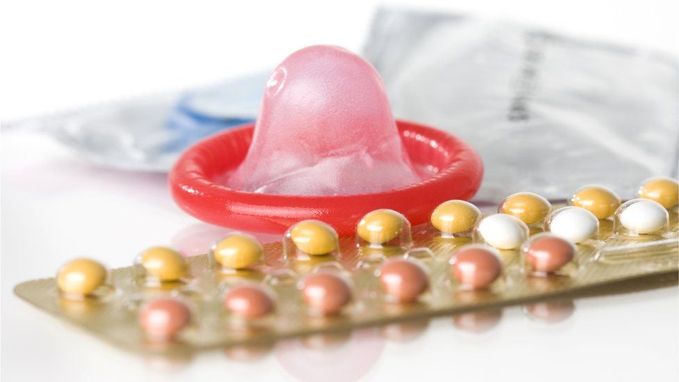 A condom and contraceptive pills