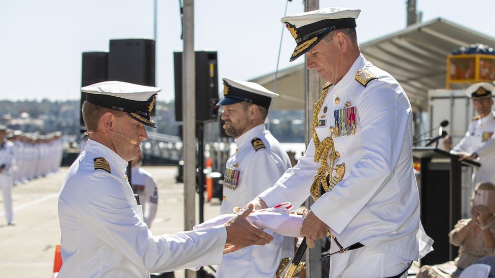 Australian naval officials conduct a ceremony at the commissioning of HMAS Supply