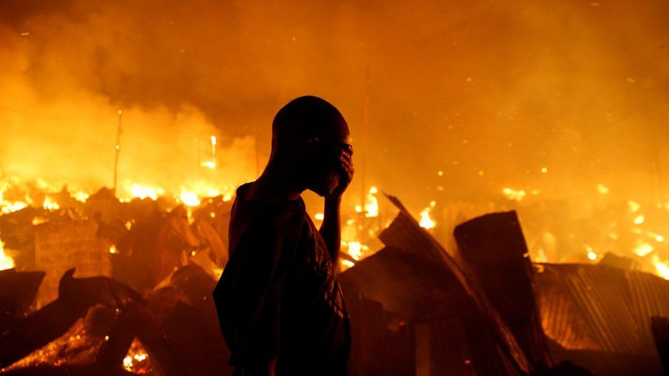 A resident of Kenyan slum attempts to extinguish a fire that broke out in the at the Kijiji slums in the Lang'ata area of the capital, Nairobi - 28 January 2018