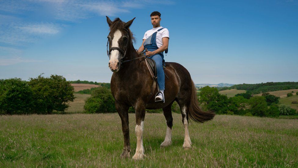 Keanan sitting on a horse in the countryside