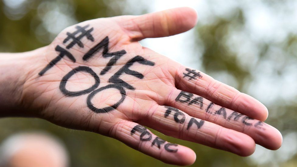 A woman has '#MeToo# and '#Balancetonporc' written on her palm at October event
