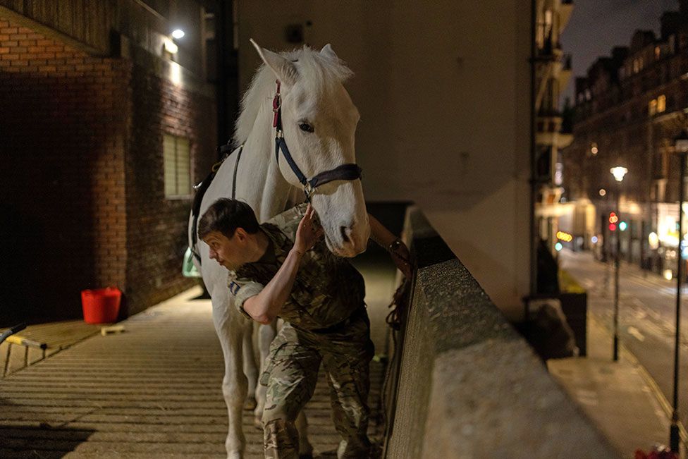 Members of the Household Cavalry Mounted Regiment prepare for a night time rehearsal for the coronation of King Charles III at Hyde Park Barracks on 17 April 2023 in London, England