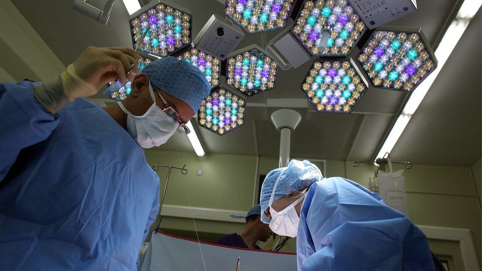 A surgeon and his theatre team performing surgery
