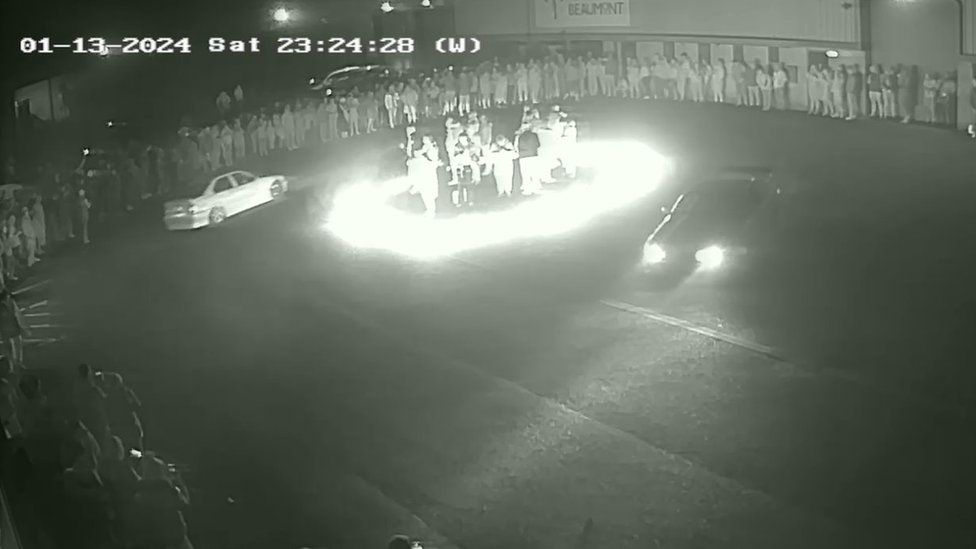 People standing in a ring of fire during a car meet