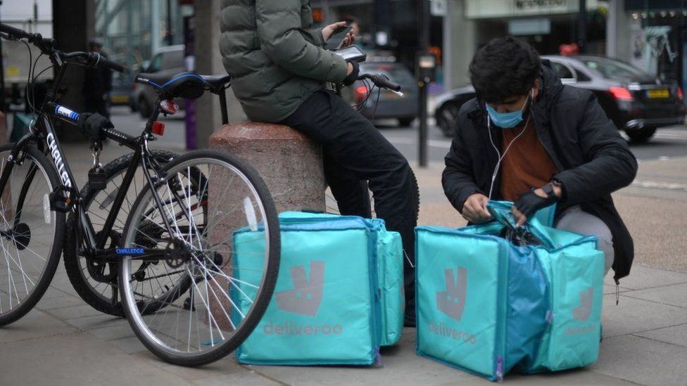 Deliveroo riders checking food bags