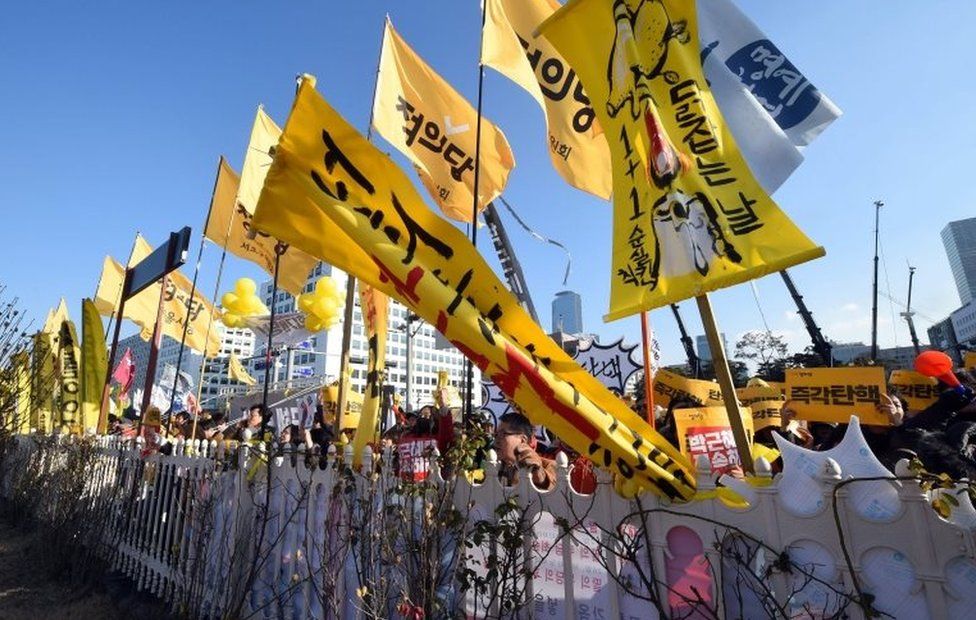 Protesters hold yellow flags during a rally urging the impeachment of South Korea's President Park Geun-Hye outside the National Assembly in Seoul on December 9, 2016