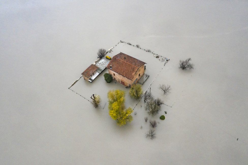 Une vue aérienne d'une maison entourée d'eaux de crue dans la vallée du Pô