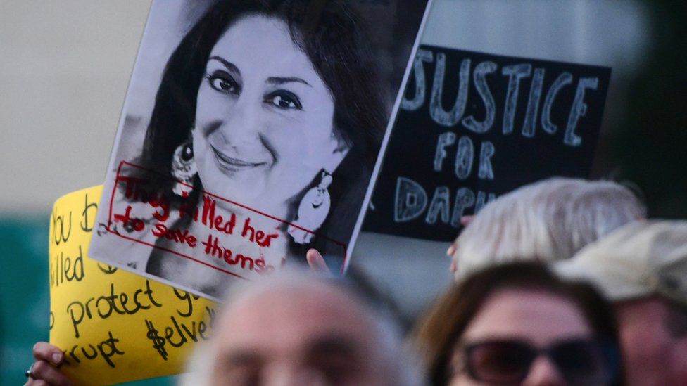 Protesters holding a photo of killed reporter Daphne Caruana Galizia