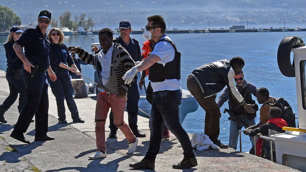 Члены береговой охраны помогают мигрантам высадиться в порту Каламата на Южном Пелопоннесе, Греция, 17 апреля 2016 г.