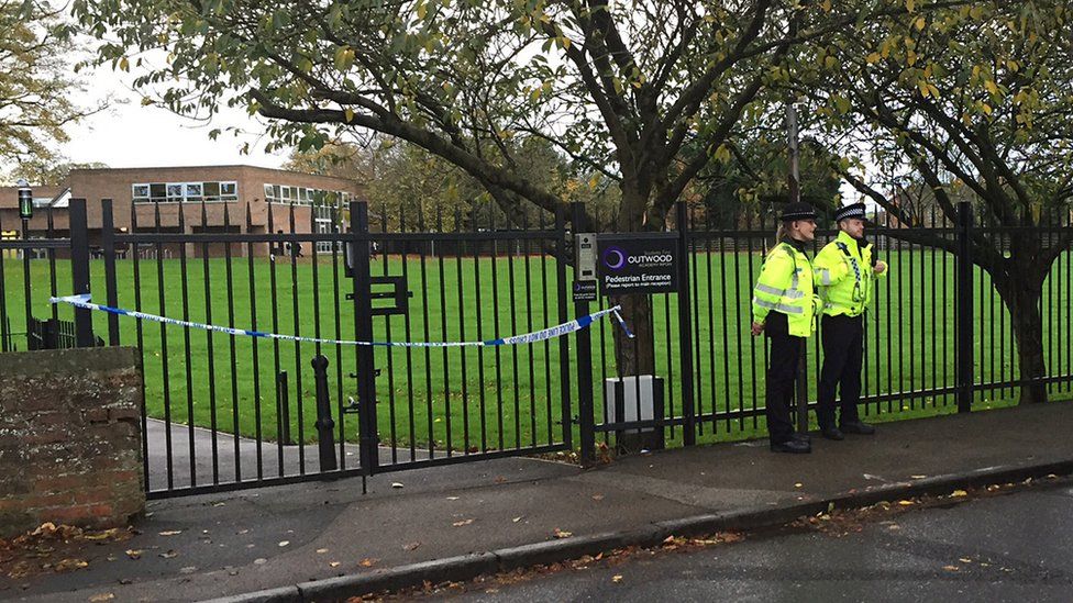 Two police officers standing outside school gates