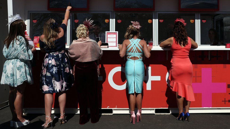 Women placing bets at Aintree