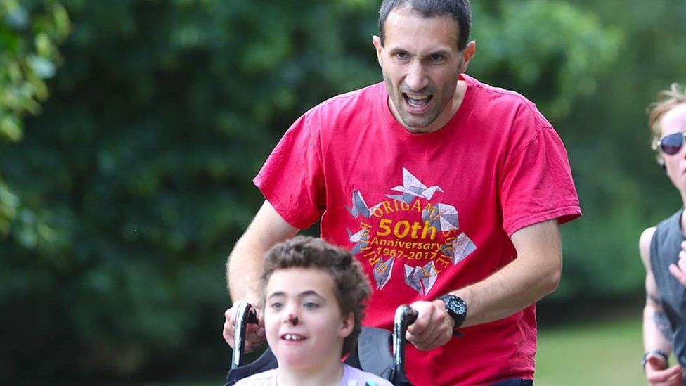 Stefano Bivini pushing his daughter Annabella in a parkrun