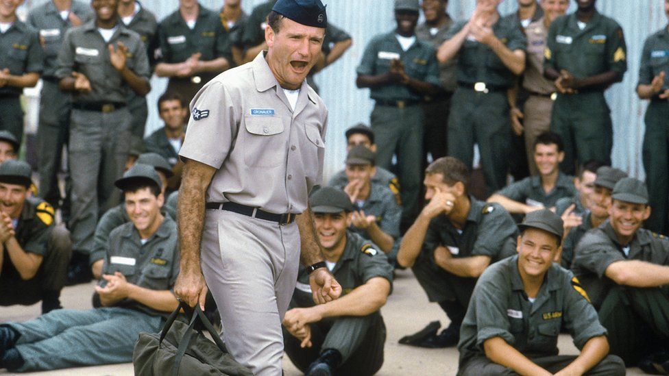 Robin Williams in the film, surrounded by personnel
