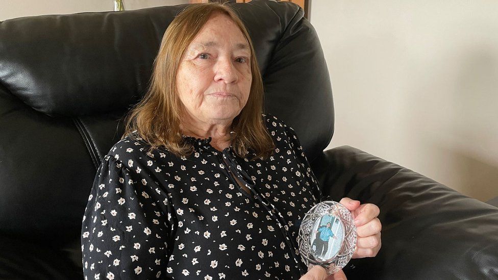 Margaret Green holding a photograph of her son George Green