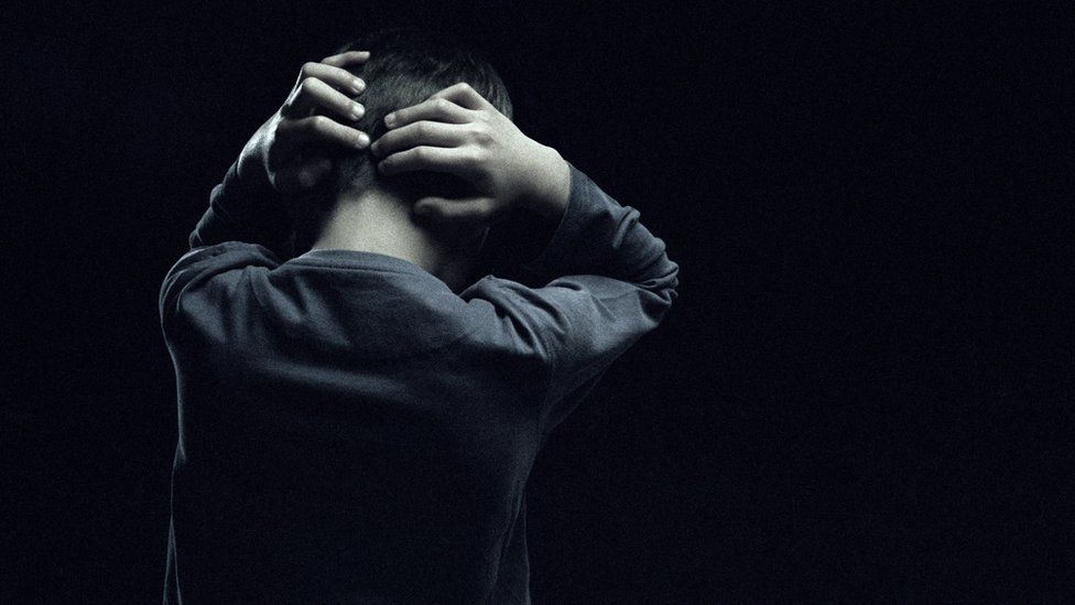 Boy with hands on back of his head