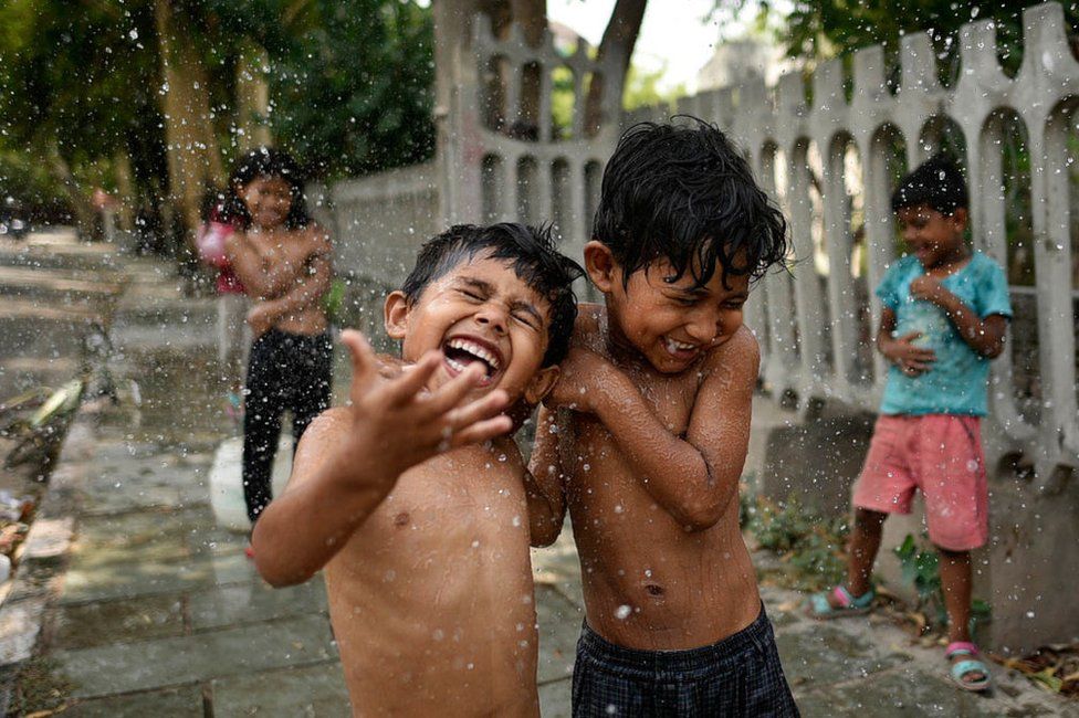 Children cool themselves off along a highway as they bathe on a hot afternoon, near Nizamuddin, on June 2, 2019 in New Delhi, India