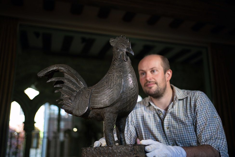 Archivist Robert Athol with a bronze statue of a cockerel called The Okukor, one of the Benin Bronzes.