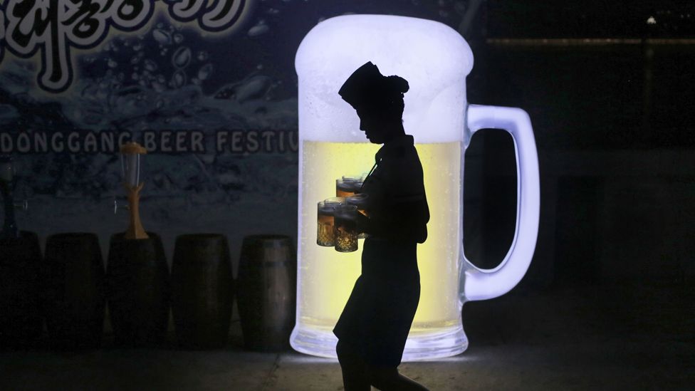 Woman carrying beer at the Pyongyang beer festival, August 2016
